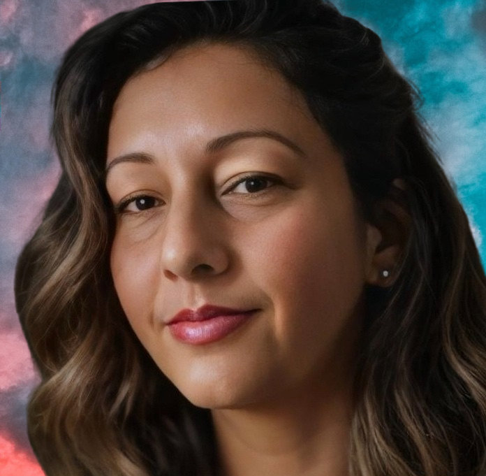 Rifa Thorpe-Tracey is pictured in front of a colourful cloud background. She has wavy shoulder length hair, stud earrings and is looking towards the camera with a small smile.
